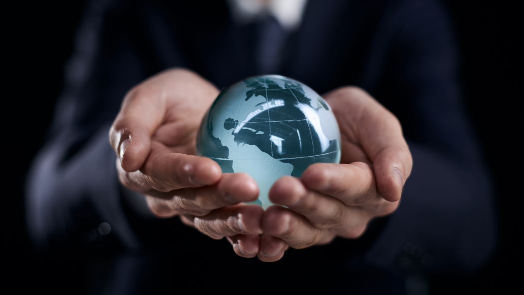 businessman-holds-glass-globe-with-continents-hands